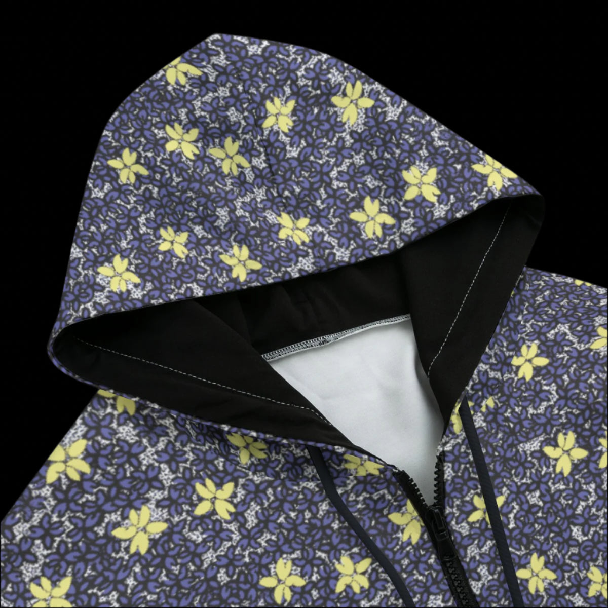 Front top of a black zipper hoodie with a floral pattern on a black background