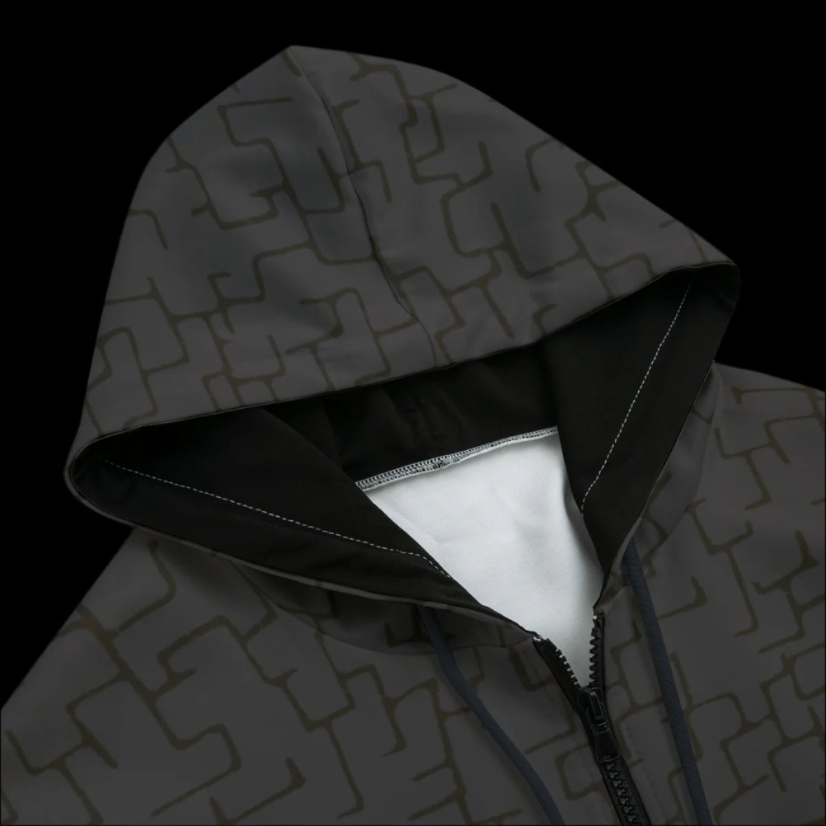 Front top of a black patterned hoodie on a black background