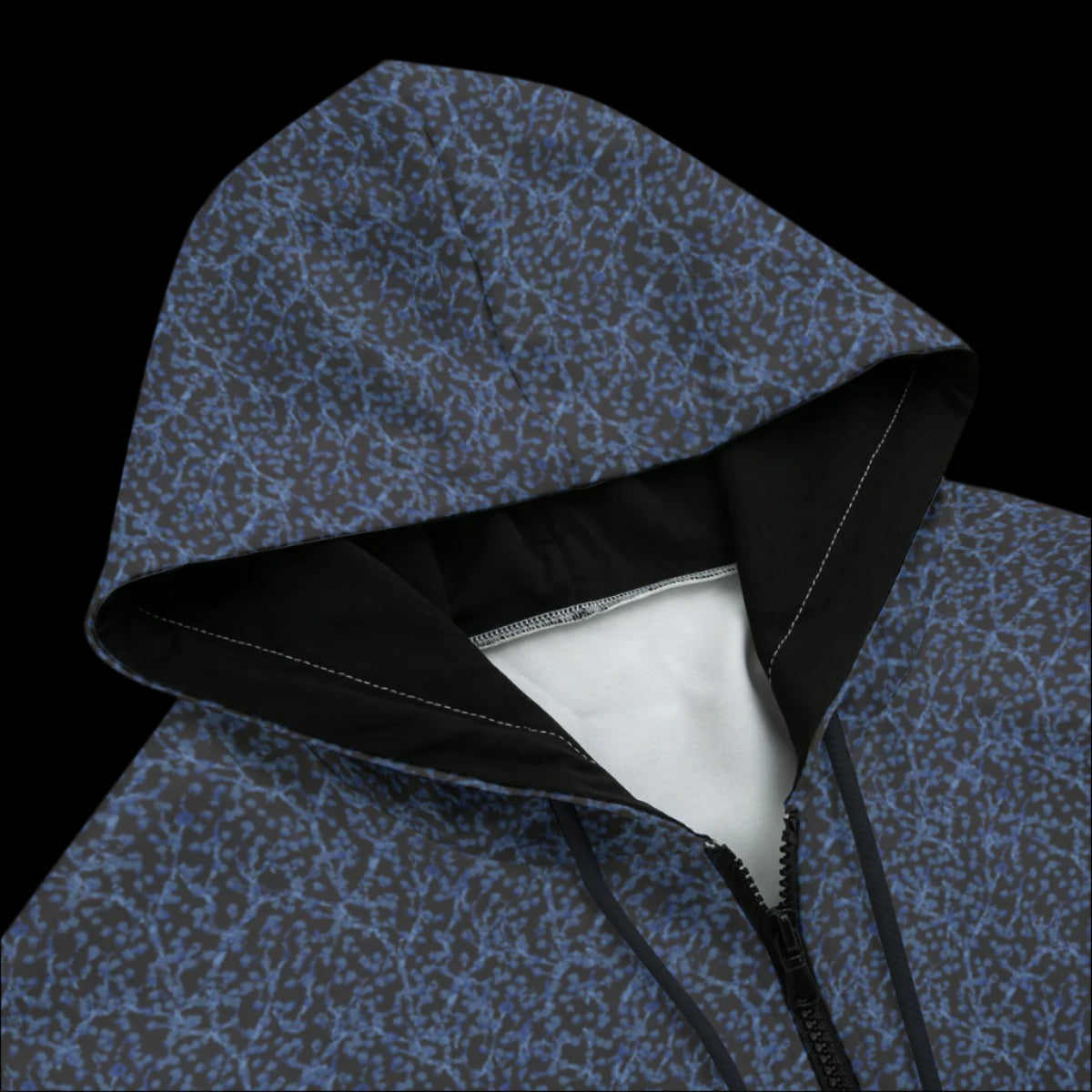 Front top of a black zipper hoodie with a blue and gray design on a black background