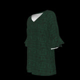 Left side of green blouse with geometric pattern on a black background