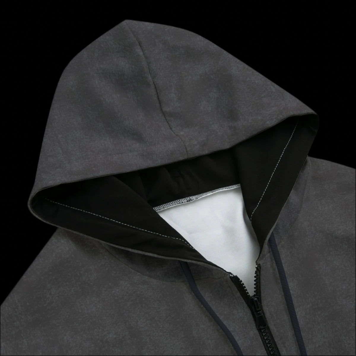 Top front of a black and grey zipper hoodie on a black background