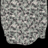 Back bottom of floral patterned long sleeve shirt on a black background